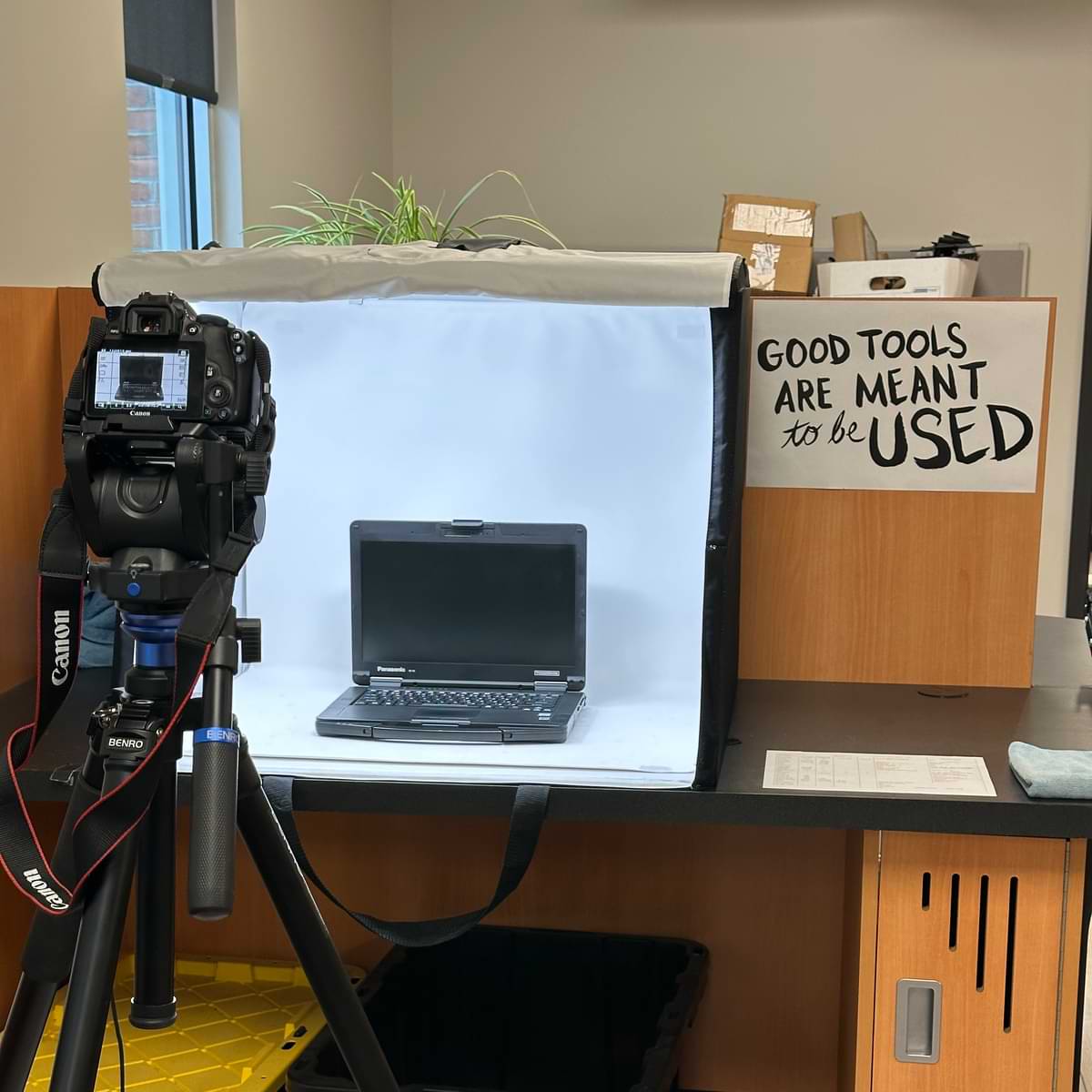 A camera on a tripod taking a picture of a Panasonic Toughbook FZ-55 in a photo booth